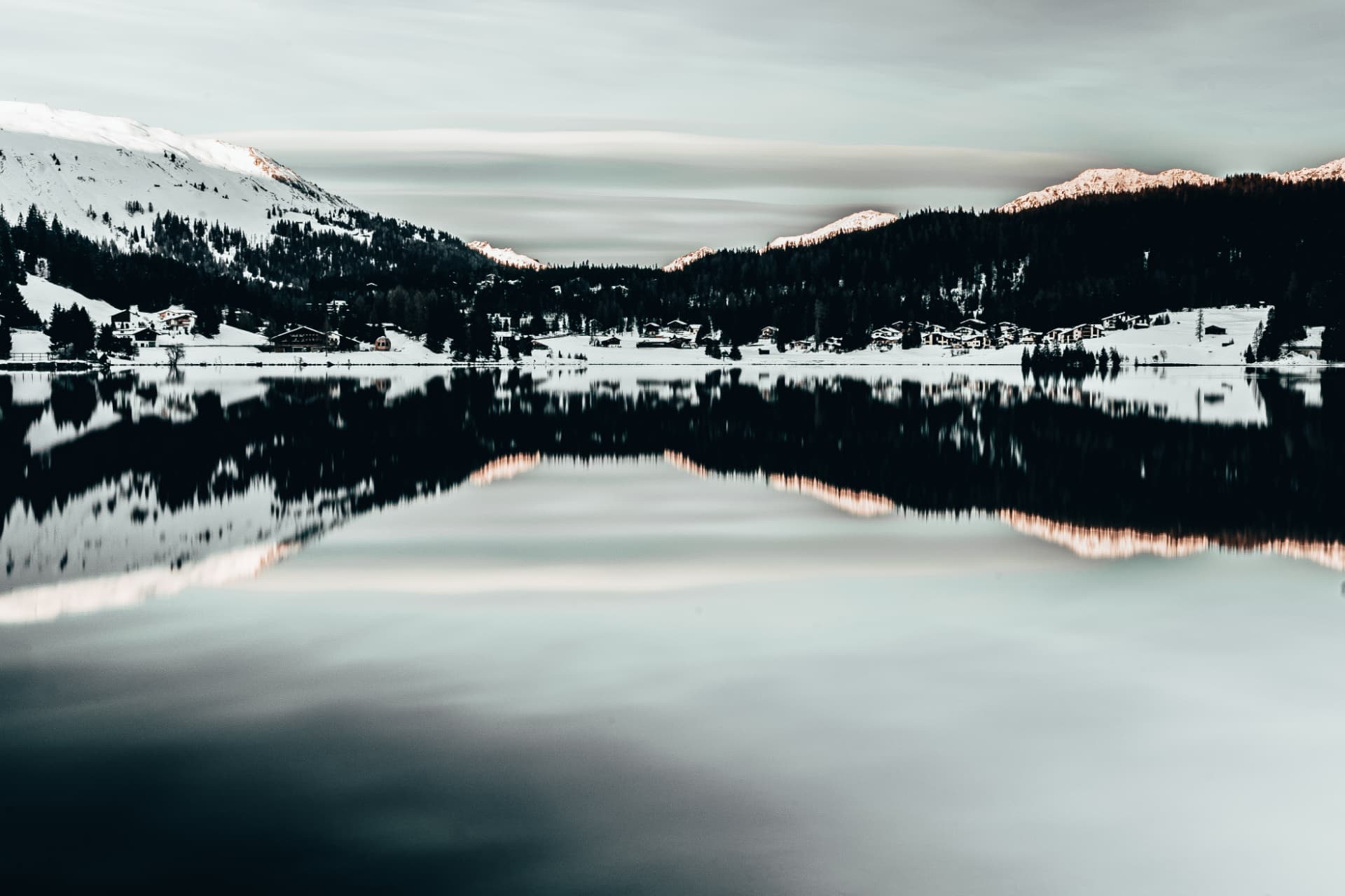 Verschneite Bergkulisse mit Spiegelung in einem ruhigen See